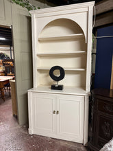 Load image into Gallery viewer, A substantial two-piece dresser combining display and storage. The upper section features three open shelves, ideal for showcasing décor or books, while the lower base provides a double cupboard for concealed storage. Built-in wiring accommodates internal lighting for ambient display. Structurally sound with good bones.
Please note: The piece shows surface marks, cable access holes on both sections, and trim is missing from the sides. Interior lighting is installed. Refinishing or repainting may enhance app
