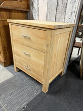 Load image into Gallery viewer, A solid oak chest of drawers in excellent working order, featuring three spacious dovetail-jointed drawers for reliable storage. The piece has been stripped to bare wood, revealing its natural grain—you may wish to apply wax or oil to protect the finish and enhance its appearance. Structurally sound and ready to use.

Delivery Available

Overall Dimensions

63cm wide x 44cm deep x 70cm high


