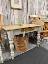 Load image into Gallery viewer, A charming vintage pine dining table with authentic character. Structurally sound and ready to use, featuring painted legs with a rustic patina that adds to its cottage appeal. One front drawer provides convenient storage, and an extendable leaf accommodates extra guests. The scrubbed pine surface showcases natural grain and warmth. Minor touch-ups to the leg paintwork would restore it to better condition, but it's perfectly functional as is. A wonderful centrepiece for family gatherings.

Delivery Availabl
