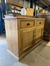 Load image into Gallery viewer, A charming Victorian pine sideboard with authentic character and patina. Structurally sound and in good overall condition, featuring two short drawers above a double cupboard with internal shelf storage. The natural wear marks reflect its age and heritage, adding to its rustic appeal. Ideal for country, farmhouse, or period-style interiors seeking genuine vintage furniture with practical storage solutions.

Delivery Available

Overall Dimensions

120cm wide x 48.5cm deep x 85cm high

