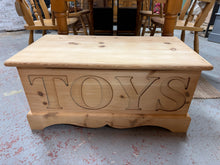 Load image into Gallery viewer, Discover the charm of authentic craftsmanship with this solid pine blanket box, lovingly stripped to reveal its natural beauty. The front features a charming TOYS engraving, making it a delightful addition to any child's room. With generous interior space, it's perfect for storing blankets, toys, and treasures. Ready for your personal touch—a protective wax finish will enhance its character and durability for years to come.

Overall Dimensions

91cm wide x 46.5cm deep x 44.5cm high

DELIVERY AVAILABLE      
