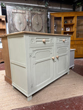 Load image into Gallery viewer, A charming oak sideboard featuring soft sage-green paint that contrast beautifully with natural wood top and hardware. Two dovetail-jointed drawers provide easy access to everyday items, while the spacious double cupboard below offers concealed storage for larger pieces. The timeless design combines practical functionality with understated elegance, perfect for dining rooms, living spaces, or hallways. It has character marks that may enhance its vintage appeal.

Delivery Available

Overall Dimensions

126cm
