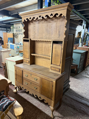 This charming oak dresser has been carefully stripped and varnished, giving it a fresh, like-new look. While it’s a pre-loved piece with some missing trim, these minor details don’t impact its functionality. The top section features 2 shelves, 2 cupboards, and 2 small drawers, while the base offers 2 cupboards and 2 sturdy dovetail-jointed drawers for ample storage. It conveniently splits into two parts for easier moving and placement.

Delivery Available

Overall Dimensions

122cm wide x 44cm deep x 202cm 