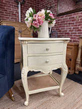 Load image into Gallery viewer, Elegant cream side table with French-inspired styling. Features two dovetail-jointed drawers for practical storage and a rattan shelf base adding natural texture. Pre-loved with light patina; structurally sound and in good condition. Perfect for bedside use or as a charming accent piece in any room.

Delivery Available

Overall Dimensions

52cm wide x 42cm deep x 72.5cm high

