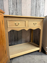 Load image into Gallery viewer, This beautiful stripped oak hall table showcases the wood's natural grain and character. Featuring traditional dovetail joinery, it includes a spacious drawer and lower shelf for practical storage. The bare wood finish allows you to personalise the look with your choice of stain or wax, making it a versatile addition to any hallway or entryway.

Delivery Available

Overall Dimensions

91cm wide x 42cm deep x 85cm high

