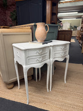 Load image into Gallery viewer, A charming pair of wooden bedside tables ready for a fresh start. Both units are structurally sound with two small drawers each, providing practical storage space. Currently showing character marks from use, these pieces are ideal for upcycling enthusiasts or those seeking vintage appeal. Perfect for a bedroom refresh with minimal effort.

Delivery Available

Overall Dimensions

36cm wide x 37cm deep x 71cm high

