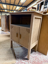 Load image into Gallery viewer, Beautifully restored oak cupboard, stripped back to showcase the natural grain and character of the wood. Structurally sound and in excellent condition. Features one convenient storage compartment, ideal for kitchens or dining areas. Requires wax protection to maintain the finish and protect the wood. A timeless piece with genuine charm and practical storage. Small hole for wires at back.

Delivery Available

Overall Dimensions

56cm wide x 35cm deep x 81cm high

