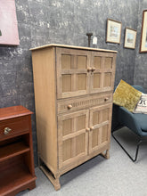 Load image into Gallery viewer, Beautifully restored oak drinks cabinet in its natural state, ready for a protective wax finish of your choice. Structurally sound with generous storage: two cupboards and one deep drawer. Perfect for displaying glassware, spirits, or entertaining essentials with timeless appeal.

Delivery Available

Overall Dimensions

82cm wide x 42.5cm deep x 128cm high

