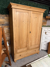 Load image into Gallery viewer, This beautiful antique pine wardrobe is solidly built and well-preserved considering its age. While it shows some minor signs of wear, these don’t affect its charm. It offers generous storage with a hanging rail, a shelf, and a spacious dovetail-jointed drawer. For convenience, it can be fully dismantled to simplify moving and includes a key for secure use.

Overall Dimensions

131.5cm wide x 59cm deep x 192cm high

DELIVERY AVAILABLE      

For our other items see our website https://fossewayfurniture.co.u
