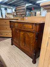 Load image into Gallery viewer, A striking mahogany serpentine sideboard combining classic design with practical storage. Features a spacious long drawer positioned above a double cupboard with internal shelf, ideal for displaying tableware or storing household essentials. The piece shows its age gracefully with minor surface marks consistent with vintage furniture. Please note: some decorative trim is missing. A characterful addition to traditional or eclectic interiors.

Delivery Available

Overall Dimensions

96cm wide x 47.5cm deep x 
