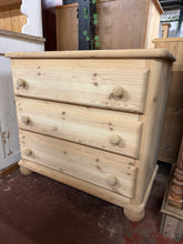 Load image into Gallery viewer, Solid pine chest of drawers with authentic stripped finish, revealing natural wood grain and character. Features three spacious dovetail-jointed drawers offering generous storage. The bare wood surface invites personalisation—apply wax or finish to suit your décor. Ideal for rustic, farmhouse, or country-style interiors seeking genuine craftsmanship and timeless appeal.

Delivery Available

Overall Dimensions

86cm wide x 46cm deep x 79.5cm high

