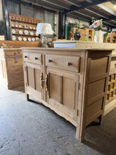 Load image into Gallery viewer, Ercol sideboard, stripped to natural wood and ready for your finishing touches. A light coat of wax will enhance the grain and protect the surface. Features two dovetail jointed drawers above a spacious double cupboard—ideal for dining room storage. Minor surface marks are present but nothing major. A timeless addition to period and contemporary homes alike.

Delivery Available

Overall Dimensions

123cm wide x 45.5cm deep x 85cm high

