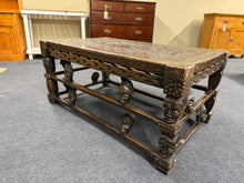 Load image into Gallery viewer, A robust solid wood table showcasing traditional African carving craftsmanship. The piece is in good working condition with minor losses—two carved heads are missing from the design, though this doesn't substantially compromise its appeal. Perfect for those seeking authentic, characterful furniture with a story, this table serves as a striking centrepiece with genuine vintage charm.

Delivery Available

Overall Dimensions

114cm wide x 67cm deep x 50cm high&nbsp;

