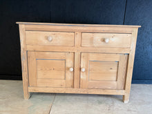 Load image into Gallery viewer, Stripped pine sideboard in its natural state, showcasing the wood's character with visible patina marks. Features two dovetail-jointed drawers above a spacious double cupboard with internal shelf. Structurally sound and ready for finishing—a light wax coat will enhance protection and bring out the grain. Perfect for those seeking genuine vintage charm with practical storage.

Delivery Available

Overall Dimensions

140.5cm wide x 47cm deep x 97cm high

