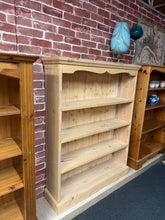 Load image into Gallery viewer, A charming stripped pine bookcase with authentic character. Featuring three fixed shelves, it's structurally sound and ready to display your collection. The natural wood finish showcases beautiful grain patterns and can be enhanced with wax or your chosen finish for added protection and durability. Ideal for period homes or anyone seeking genuine vintage appeal.

Delivery Available

Overall Dimensions

96cm wide x 24cm deep x 122cm high

