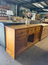 Load image into Gallery viewer, Solid pine construction with dovetail-jointed drawers ensures durability and lasting appeal. This sideboard features three spacious drawers and two cupboards, offering flexible storage for dining rooms, hallways, or living spaces. Light surface marks and patina add character while the structural integrity remains excellent. A practical, characterful piece ready to enhance any home.

Delivery Available

Overall Dimensions

152cm wide x 45cm deep x 82cm high

