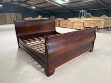 Load image into Gallery viewer, A magnificent Super King Sleigh Bed in rich mahogany, offering timeless elegance for your bedroom. This structurally sound piece is in good overall condition with some cosmetic marks consistent with its pre-loved status. Fully functional and ready to use—note that one slat requires replacement. Designed for easy transport, it disassembles into four substantial sections plus individual slats, making moving and setup straightforward. An ideal choice for those seeking classic style and practical functionality.

