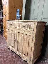 Load image into Gallery viewer, A beautiful stripped oak sideboard that celebrates natural wood grain and character. Features two dovetail-jointed drawers over a double cupboard with an internal shelf, offering practical storage with authentic craftsmanship. The natural finish may benefit from a protective coat of wax to enhance durability and lustre. An ideal statement piece for period properties or contemporary interiors seeking genuine wooden furniture.

Delivery Available

Overall Dimensions

95cm wide x 44cm deep x 89cm high

