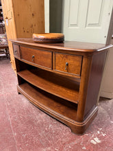 Load image into Gallery viewer, A timeless mahogany bookcase combining elegant craftsmanship with practical storage. Features two short and one long dovetail-jointed drawers and a generous open shelf, perfect for displaying books and treasured items. Rear cable access keeps cords discreetly hidden. Structurally sound with character marks that speak to its quality construction and enduring appeal.

Delivery Available

Overall Dimensions

120cm wide x 45cm deep x 81cm high

