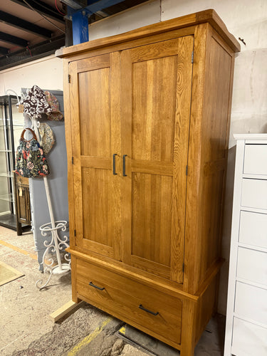 The Harrogate Rustic Solid Oak Double Wardrobe is a classic and durable storage solution, crafted from 100% solid oak with a deep rustic finish that enhances the natural wood grain.Designed for practicality and style, it features two doors opening to a spacious hanging area, perfect for organising clothes.Below, a wide dovetail jointed drawer on traditional wooden runners provides additional storage for accessories. Sturdy metal handles complete its timeless look, making it an ideal addition to an