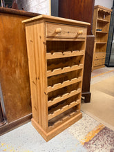 Load image into Gallery viewer, A charming solid pine wine rack with authentic character. This sturdy piece features a spacious drawer for storing accessories. Holds 24 bottles with ease. Shows gentle signs of use that add to its vintage appeal—perfect for those who appreciate well-loved furniture with history.

Delivery Available

Overall Dimensions

53cm wide x 32cm deep x 108cm high

