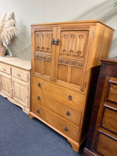 Load image into Gallery viewer, Crafted from oak, this elegant drinks cabinet combines timeless style with practical storage. The piece features a spacious double cupboard with internal shelf, complemented by three dovetail-jointed drawers offering generous room for glassware, bottles, and entertaining essentials. With its sturdy construction and characterful patina, it's a sophisticated addition to any dining room or living space.

Delivery Available

Overall Dimensions

85cm wide x 46cm deep x 133cm high

