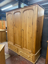 Load image into Gallery viewer, A characterful vintage pine triple wardrobe with genuine period appeal. Structurally sound with quality dovetail jointed drawers. One door shows minor warping; hanging rail can be added. Dismantles into three sections for convenient transport and placement. Surface patina and marks add to its vintage charm and can be refreshed with wax or paint to suit your décor. An authentic statement piece for period homes or eclectic interiors.

Delivery Available

Overall Dimensions

156cm wide x 56cm deep x 188cm high
