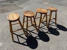 Load image into Gallery viewer, A charming set of four solid wooden stools, each structurally sound and ready for everyday use. These pre-loved pieces bear the gentle patina of age with minor surface marks that add character rather than detract from their appeal. Ideal for tucking under a dining table, they offer practical seating with authentic vintage charm. A versatile addition to any home seeking functional, characterful furniture.

Delivery Available

Overall Dimensions

approx : 34cm x 24cm x 53cm high


