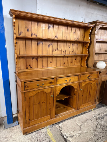 This beautiful solid pine dresser is sturdy and well-maintained. While it shows some minor marks, they aren't major. It offers plenty of storage space with three dovetail-jointed drawers above two cupboards and a shelf. The upper section includes two additional shelves. For convenience, the top separates from the base, making it easier to move.

Overall Dimensions

173cm wide x 57cm deep x 188cm high

DELIVERY AVAILABLE      

HAVE THIS PAINTED A COLOUR OF YOUR CHOICE FOR AN EXTRA £120 OR HAVE IT COMPLETELY