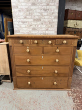 Load image into Gallery viewer, A spacious mahogany chest featuring eight drawers in varying sizes—three short, two medium, and three long—offering generous storage capacity. The piece has been stripped to reveal its natural wood finish and would benefit from waxing to protect the surface. Minor cosmetic wear includes missing trim and skirt detailing, though these do not affect functionality. An authentic vintage find with character and practical appeal.

Delivery Available

Overall Dimensions

126cm wide x 56.5cm deep x 114cm high

