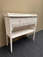 Load image into Gallery viewer, This white console table offers practical storage with two drawers and a lower shelf, making it ideal for entryways or living spaces. Currently in fair condition with solid construction, it's a great candidate for refinishing—a fresh coat of paint would restore it to like-new appearance. Perfect for those looking to upcycle or customise a piece to match their décor.

Delivery Available

Overall Dimensions

80cm wide x 28.5cm deep x 80cm high

