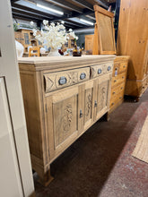 Load image into Gallery viewer, A striking stripped oak sideboard that showcases natural wood grain and carved detailing. Features two dovetail-jointed drawers above a spacious double cupboard, combining storage with timeless style. Structurally sound and ready for finishing—apply wax or oil to protect the bare wood and enhance the grain. An impressive focal point for any dining room or hallway.

Delivery Available

Overall Dimensions

138cm wide x 46cm deep x 93.5cm high

