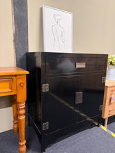 Load image into Gallery viewer, Beautiful Oriental sideboard with character and charm. Structurally sound and in good working condition, showing only minor signs of gentle use that add to its vintage appeal. Features one spacious drawer positioned above a double cupboard, offering generous storage for everyday essentials. Practical cable management holes inside the cupboard keep cords discreetly organised. A striking statement piece that brings warmth and sophistication to any room, whether styled as a living room accent or bedroom storag
