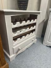 Load image into Gallery viewer, A charming grey distressed wine rack with authentic vintage character. Holds 15 bottles securely and features a practical base drawer for storing glasses, accessories, or table linens. Structurally sound with gentle wear that adds to its rustic appeal. Perfect for wine enthusiasts seeking functional, characterful storage with timeless style.

Delivery Available

Overall Dimensions

80cm wide x 30cm deep x 77cm high

