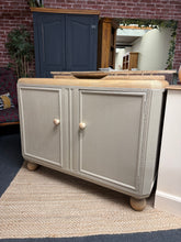 Load image into Gallery viewer, A sophisticated oak sideboard featuring Farrow &amp; Ball's 'London Stone' finish, complemented by natural oak top, knobs, and feet. This versatile piece offers generous storage with one spacious drawer and internal shelf, perfect for living rooms or dining spaces. Structurally sound and beautifully maintained, it combines timeless design with practical functionality.

Delivery Available

Overall Dimensions

121cm wide x 49cm deep x 90cm + 4cm high&nbsp;

