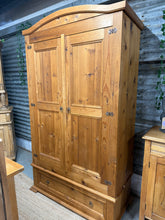 Load image into Gallery viewer, Solid pine wardrobe in good condition with natural wear marks that don't affect functionality. Features one hanging rail and a spacious dovetail-jointed drawer for storage. Disassembles into three sections for convenient moving and installation, with the cupboard forming the largest component. Ideal for adding warmth and character to any bedroom.

Delivery Available

Overall Dimensions

113cm wide x 55cm wide x 198cm high

