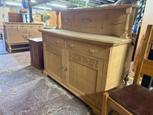 Load image into Gallery viewer, A beautiful solid oak sideboard, stripped back to reveal its natural grain and character. Features two dovetail-jointed drawers positioned above two single cupboards, providing generous storage for dining rooms or living spaces. The removable top backboard offers flexible styling options. Its stripped finish may benefit from a protective coat of wax. Minor surface cracks are present and add to its authentic vintage appeal without affecting functionality or durability.

Delivery Available

Overall Dimensions
