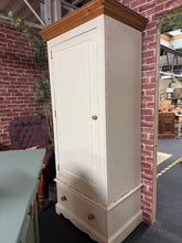 Load image into Gallery viewer, A charming solid pine single wardrobe with authentic character. Structurally sound and in good overall condition, this piece bears the honest marks of its history—chips and wear that add vintage appeal. Features one hanging rail for clothes storage and a dovetail-jointed drawer for folded items or accessories. Designed for practical living, it disassembles completely for straightforward moving and repositioning. A timeless addition to bedrooms seeking warmth and functionality.

Delivery Available

Overall D
