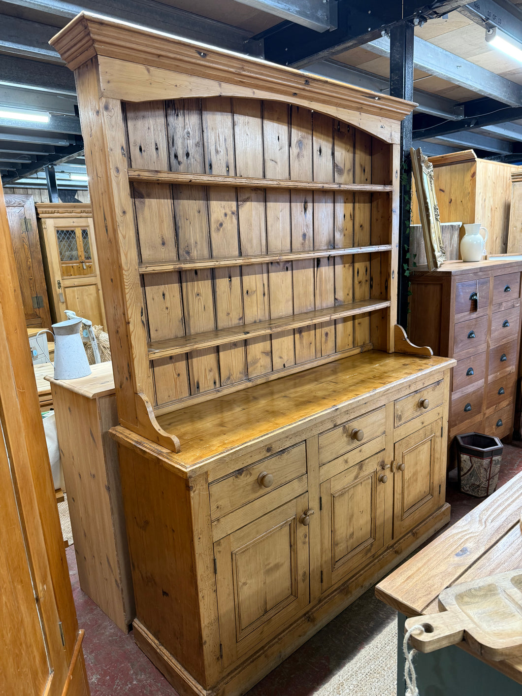 This exquisite reclaimed pitch pine dresser is structurally sound and remains in excellent condition considering its age. Featuring 3 fixed shelves in the top section, and 3 drawers and 2 cupboards in the base, it provides ample storage. The top section can be easily detached from the base for convenient transport. While there are some minor marks from previous use, they only enhances its character.

Overall Dimensions

156cm wide x 47cm deep x 203.5cm high

DELIVERY AVAILABLE      

For our other items see