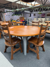 Load image into Gallery viewer, This charming solid pine round dining table combines classic style with practical functionality. The sanded and varnished top showcases the natural beauty of the wood, while the grey-painted legs add contemporary contrast. Structurally sound and well-maintained, it comfortably seats six diners and features fixed legs for stability. Minor surface marks add to its authentic character. Perfect for family gatherings and everyday dining.

Delivery Available

Overall Dimensions

147cm diameter x 75cm high

