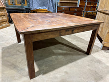 Load image into Gallery viewer, A spacious hardwood dining table with authentic character, featuring a sturdy square design that accommodates 10-12 guests. Two end drawers provide convenient storage for table linens and cutlery. As a pre-loved piece, it bears the natural patina of use—minor surface marks and a small corner crack that don't compromise its structural integrity or functionality. Ideal for those seeking genuine quality with honest, lived-in charm.

Delivery Available

Overall Dimensions

151cm wide x 151cm deep x 77cm high

