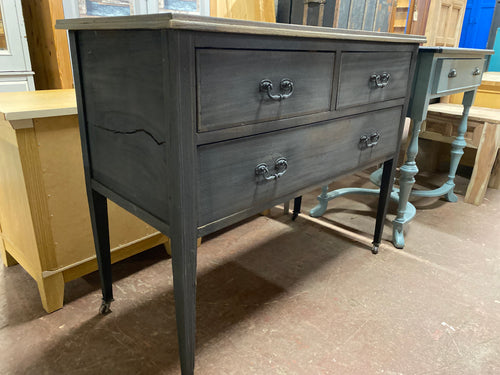 Get ready to fall in love with this incredible chest of drawers! The base has been treated with a beautiful ash-colored wax, while the top boasts a darker wax for a unique touch. With 2 short drawers and 1 long one, all dovetail jointed, you'll have plenty of storage space. Don't worry about the crack on one side, it's just a little quirky detail that doesn't affect the functionality at all!  