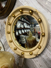 Load image into Gallery viewer, Elevate your home decor with this exquisite convex Porthole Mirror, inspired by the elegant regency style. Boasting a sturdy structure and excellent condition, this timeless piece adds a touch of sophistication to any room it graces. Indulge in the beauty and charm of this stunning Arts Décoratif mirror today.  Overall Dimensions  33.5cm diameter     DELIVERY AVAILABLE      For our other items see our website https://fossewayfurniture.co.uk 
