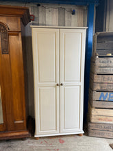 Load image into Gallery viewer, This sweet pine wardrobe has been painted in a cream colour with the knobs and bun feet left natural. It is structurally sound and in overall good condition. Inside there is 1 long hanging rail and 1 shelf for storage.

Overall Dimensions

88cm wide x 57cm deep x 185cm high

DELIVERY AVAILABLE    

For our other items see our website https://fossewayfurniture.co.uk

collection from cv36 or delivery available 


