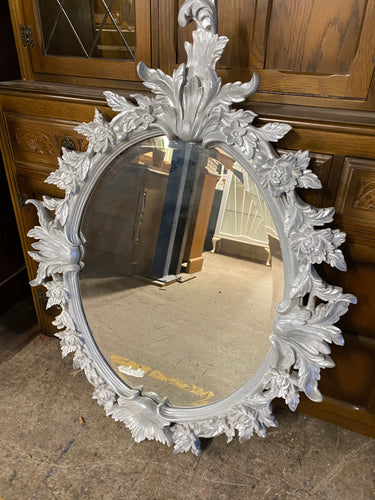 Add a touch of elegance to your home with this beautifully designed silver wall mirror. The beveled edges add a modern touch while the intricate details of leaves and flowers add a timeless charm. This oval mirror is in excellent condition and sturdy enough to last for years to come.  Overall Dimensions  80cm x 107cm      DELIVERY AVAILABLE      For our other items see our website https://fossewayfurniture.co.uk