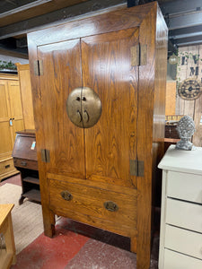 This durable, oriental-inspired wardrobe boasts a sturdy, solid wood construction and is in great condition overall. While there are some minor markings due to previous use, it is still very well-maintained. It features one hanging rail and a removable, adjustable shelf inside, as well as a discreetly placed hole in the back for wires (this was put in by previous owners). One of the legs has a small amount of damage, but it does not impact functionality.

Overall Dimensions

115cm wide x 58cm deep x 207cm h