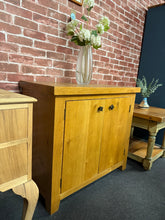 Load image into Gallery viewer, A sturdy oak cupboard offering practical storage solutions. Featuring a double cupboard design with internal shelf, it provides ample space for your belongings. The piece is structurally sound and in good overall condition, with minor cosmetic marks. Ideal for hallways, bedrooms, or living spaces where reliable storage is needed.

Delivery Available

Overall Dimensions

90cm wide x 42.5cm deep x 80cm high

