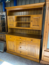 Load image into Gallery viewer, Built with sturdy solid oak and in excellent condition, this heavy dresser offers ample storage with 6 dovetail jointed drawers, 2 single cupboards in the base, and 1 full length shelf, 2 half shelves, and 2 cupboards in the top section. Although there are some slight marks on the top, it is still a great piece. Plus, it comes apart in 2 sections for easy moving.  Overall Dimensions  151cm wide x 48cm deep x 199cm high   DELIVERY AVAILABLE      
