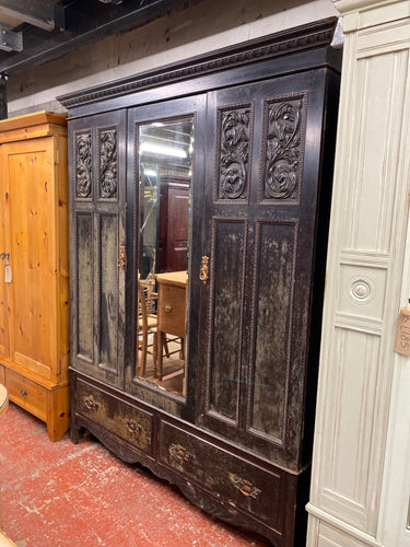 This marvellous antique effect black wooden wardrobe is impressively sturdy and in excellent condition. It features 2 hanging rails and 2 long dovetail jointed drawers for ample storage. It can be disassembled into sections for effortless transportation.