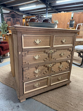 Load image into Gallery viewer, A characterful geometric oak chest of drawers with solid construction and authentic vintage patina. Features four short drawers and two generous long drawers, offering flexible storage solutions. Recently stripped to bare wood, revealing the natural grain—ideal for refinishing to your preferred style, or leave as-is for rustic appeal. Minor cosmetic marks and missing trim add to its period charm. Ready for waxing or your chosen finish.

Delivery Available

Overall Dimensions

93cm wide x 55cm deep x 93cm hi
